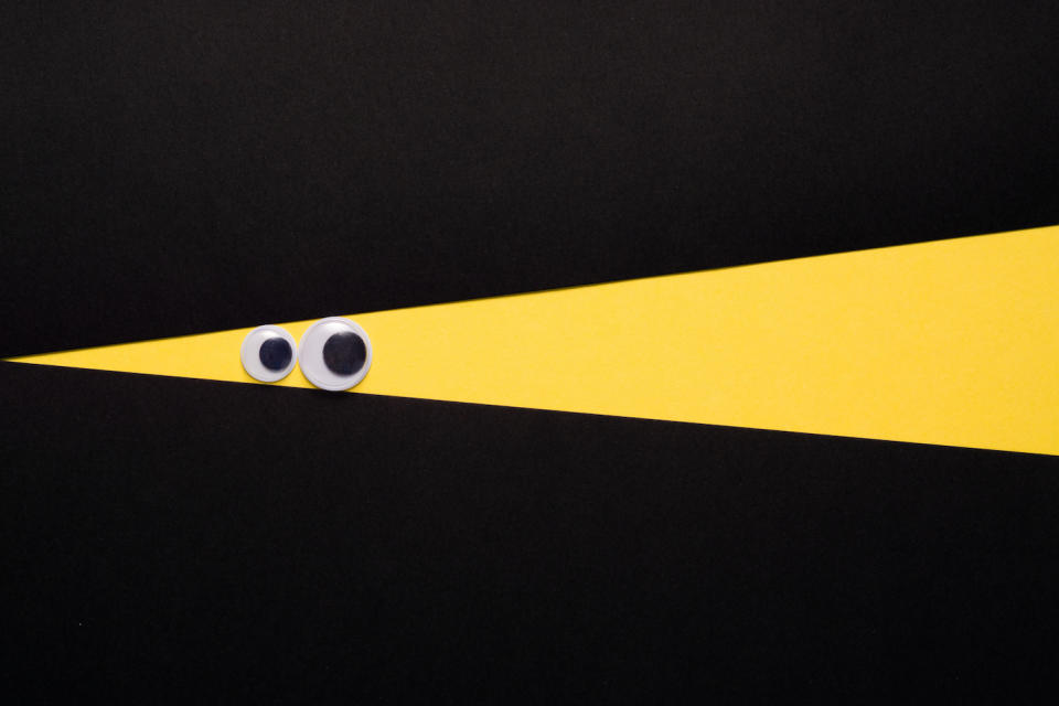 Cartoon Style Eye Peeping through Yellow Color on Paper Texture