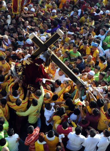 Philippine Catholic pilgrims carry the statue of the Black Nazarene, a life-size icon of Jesus Christ carrying a cross, to mark the annual day-long religious procession in Manila on January 9, 2012. A human sea of Catholic pilgrims flooded the Philippine capital on January 9, to join a religious march, police said, defying government warnings of a potential terror attack on the annual festival. AFP PHOTO/TED ALJIBE