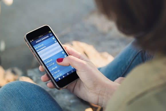 Woman on smartphone performing online banking transaction.