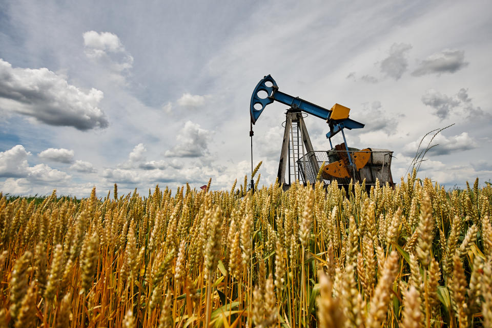 Oil pump in the wheat field, oil industry equipment