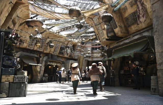 Characters stroll through the marketplace at the Black Spire Outpost at Star Wars: Galaxy's Edge at Disneyland