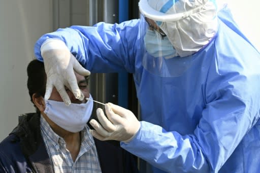 Un médico toma muestras para una prueba de PCR a un hombre con síntomas de COVID-19 en la unidad móvil de salud en Villa Fiorito, en las afueras de Buenos Aires, el 3 de agosto de 2020 (AFP | JUAN MABROMATA)