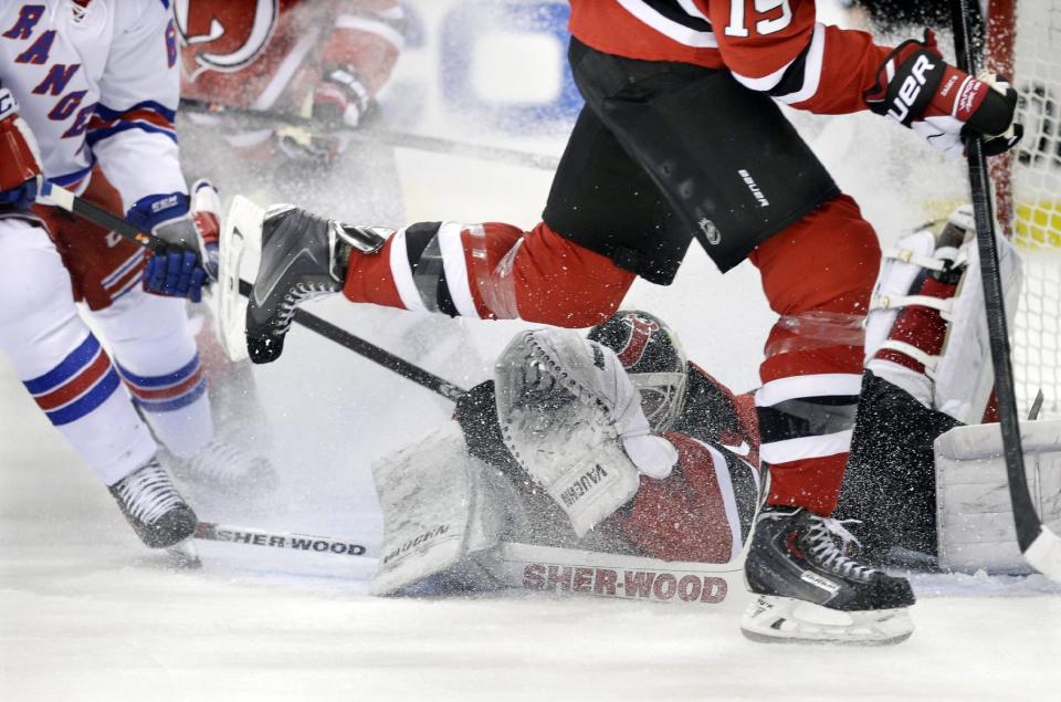 New Jersey Devils goalie Martin Brodeur falls in front of the goal as he blocks a shot during the first period of an NHL hockey game against the New York Rangers on Saturday, March 22, 2014, in Newark, N.J. (AP Photo/Mel Evans)