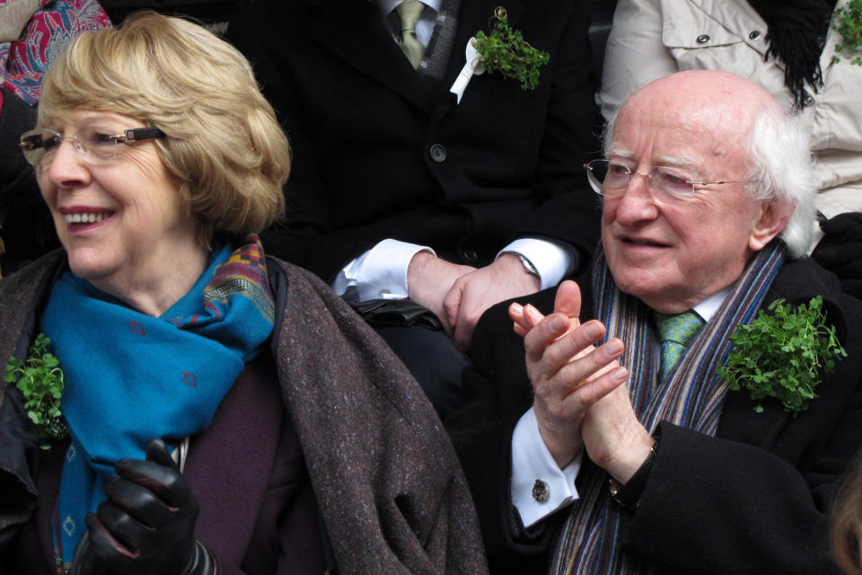 CAPTION CORRECTION, CORRECTS NAME OF WIFE - Ireland's President Michael D. Higgins, right, and his wife Sabina don sprigs of shamrock as they applaud passing groups at the St. Patrick's Day parade, Dublin, Sunday, March 17, 2013. Never mind the fickle Irish weather. A chilly, damp Dublin celebrated St. Patrick's Day with artistic flair Sunday as the focal point for a weekend of Irish celebrations worldwide. (AP Photo/Shawn Pogatchnik)