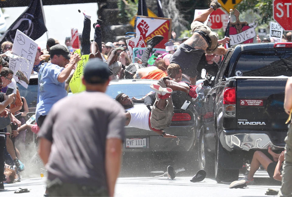 Marcus Martin, seen in a white shirt, pushed his fiancee out of the way before a car targeting anti-racist protestors hit him instead. (Photo: Ryan M Kelly/The Daily Progress)