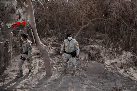 Police officers keep watch at an area affected by the eruption of the Fuego volcano at El Rodeo in Escuintla, Guatemala June 5, 2018. REUTERS/Jose Cabezas