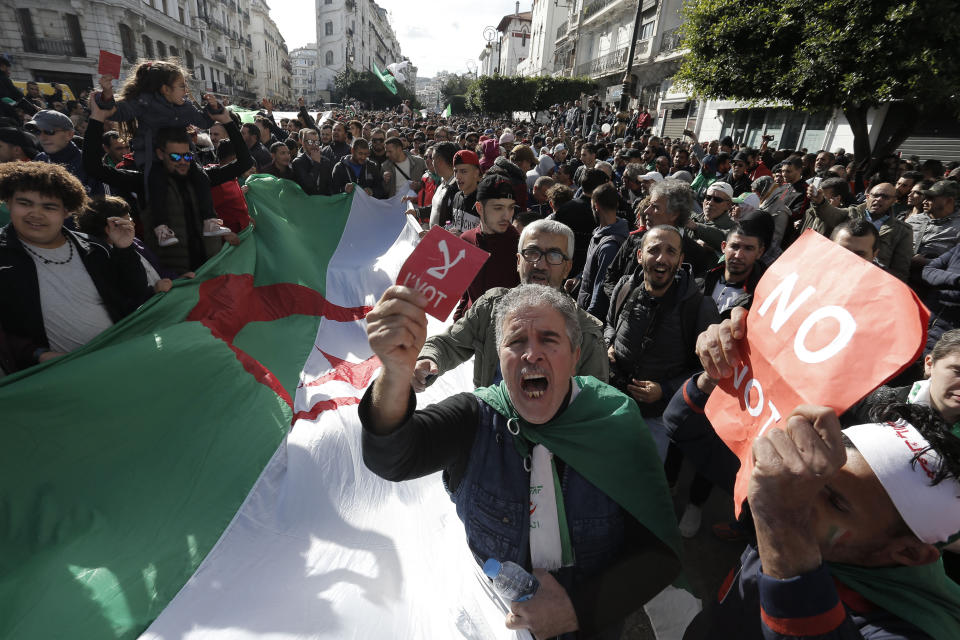 Algerian demonstrators take to the streets in the capital Algiers to reject the presidential elections, in Algeria, Thursday, Dec. 12, 2019. Five candidates have their eyes on becoming the next president of Algeria _ without a leader since April _ in Thursday's contentious election boycotted by a massive pro-democracy movement. (AP Photo/Toufik Doudou)