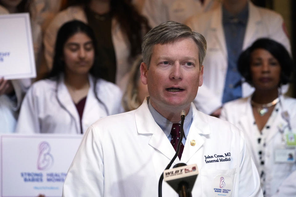 Dr. John Cross, president of the Mississippi State Medical Association, flanked by physicians and medical schools students, calls for the legislature's support of extending postpartum Medicaid coverage to 12 months, during a news conference at the Capitol in Jackson, Miss., Wednesday, Feb. 22, 2023. (AP Photo/Rogelio V. Solis)