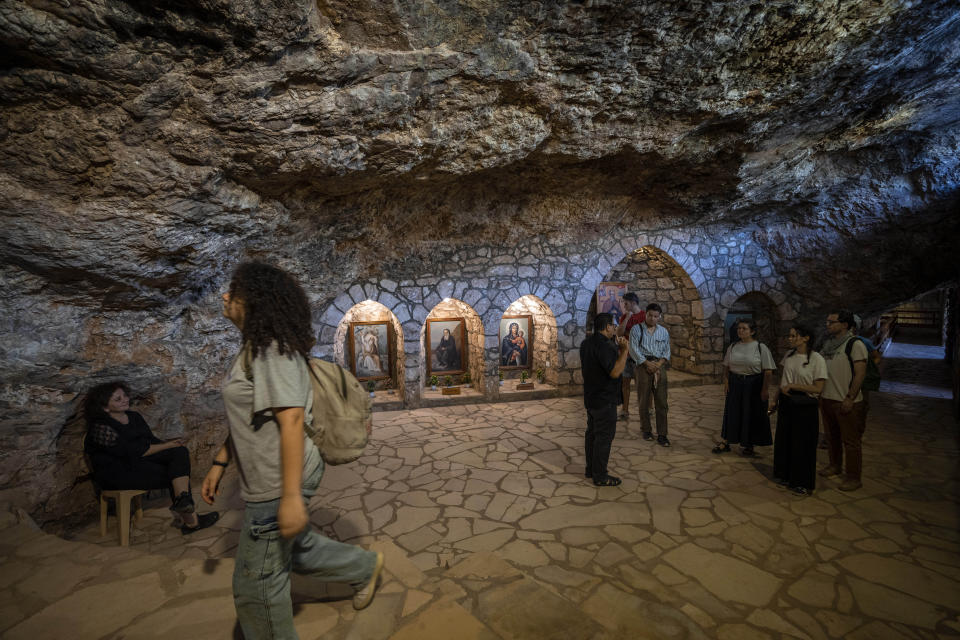 Lebanese priest Hani Tawk, center, gives French tourists a tour of the Saint Elisha monastery, located in the Kadisha Valley, a holy site by Lebanon's Christians, in the northeast mountain town of Bcharre, Lebanon, Saturday, July 22, 2023. For Lebanon's Christians, the cedars are sacred, these tough evergreen trees that survive the mountain's harsh snowy winters. They point out with pride that Lebanon's cedars are mentioned 103 times in the Bible. (AP Photo/Hassan Ammar)