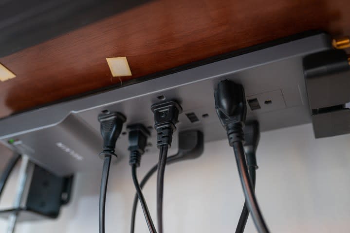 A power strip attached under a desk.