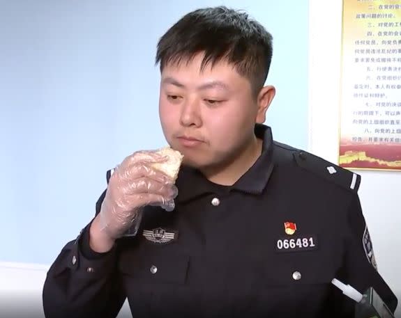 The officer tucks into a piece of durian fruit during the experiment. (Pear Video)