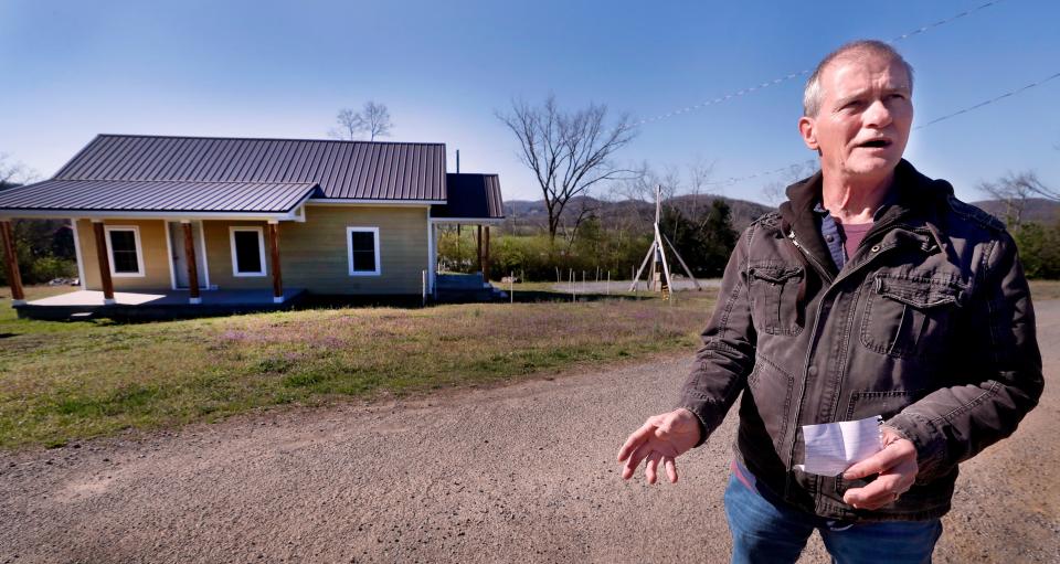 James Pitts stands in front of his property, on Thursday, March 28, 2024, in the Cannon County side of the Readyville community where he and his wife, Sonia, were in their RV when a tornado hit almost a year ago, as they were in the process of building their home on the site. The storm flipped the RV that was knocked into a tree, which could have prevented it from rolling down the hill.