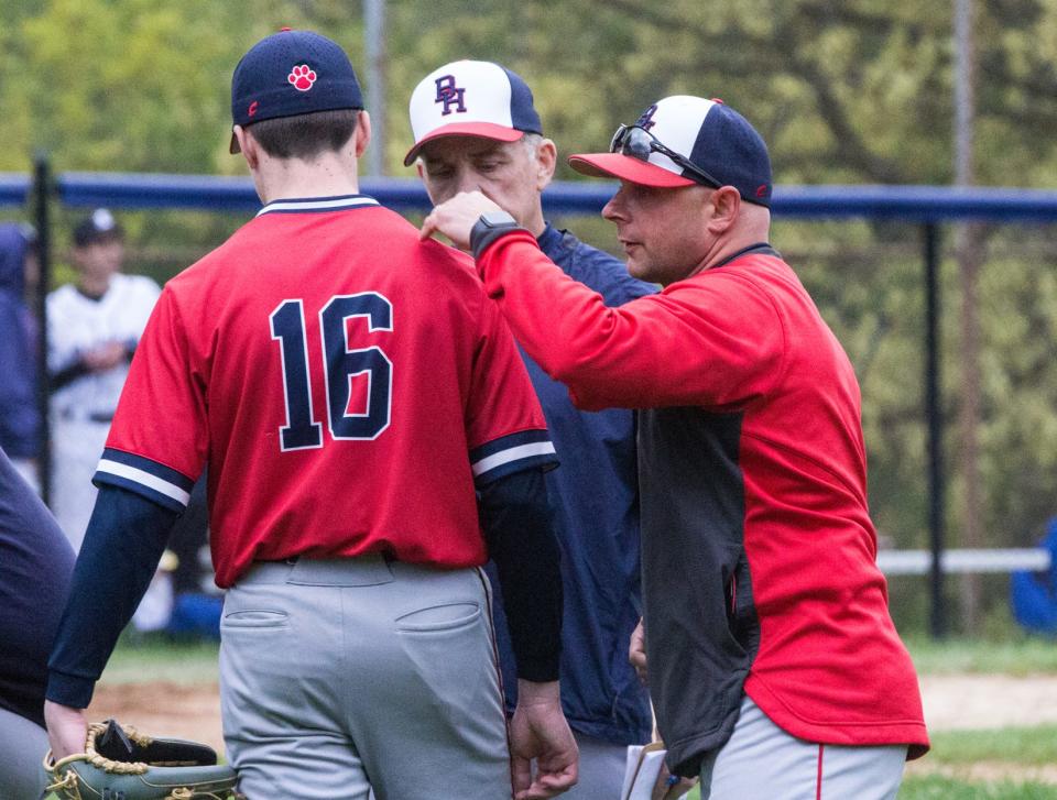Byram Hills head coach Scott Saunders (right), meets with Brandon Kriegel (16) and assistant coach Fred Schwam during their game against Edgemont on Monday, May 1, 2023.