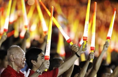 Singapore's former Prime Minister Lee Kuan Yew (L) waves a light stick during Singapore's national day parade celebrations August 9, 2013. REUTERS/Edgar Su/Files