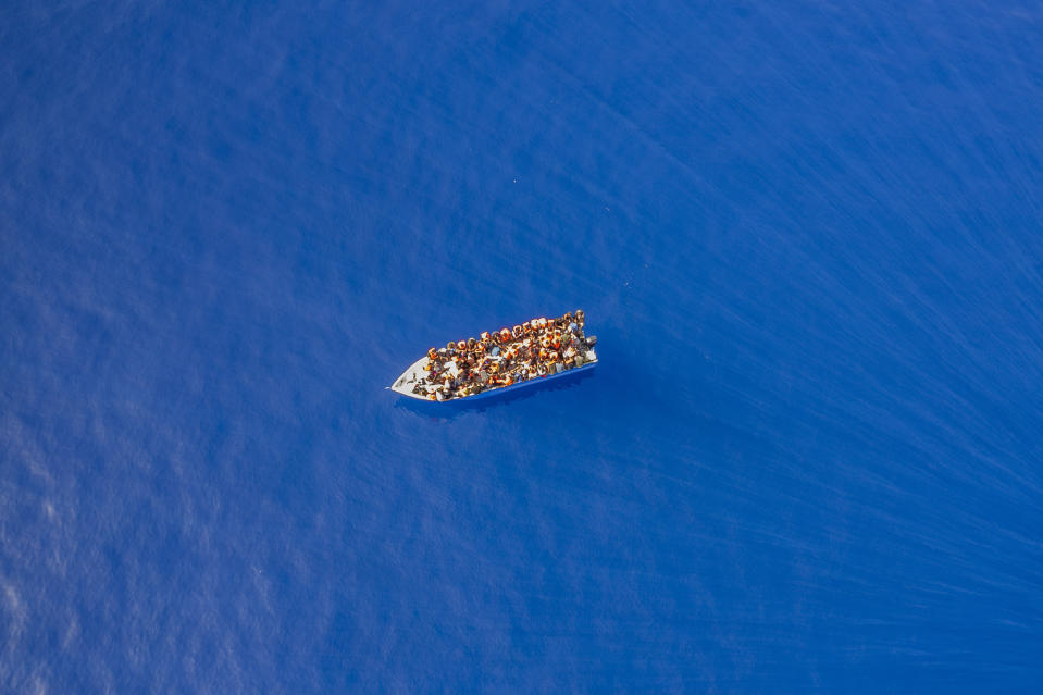 A group thought to be migrants from Tunisia on board a precarious wooden boat waits to be assisted by a team of the Spanish NGO Open Arms, around 20 miles southwest from the Italian island of Lampedusa, in Italian SAR zone, Thursday July 29, 2021. The NGO assisted more than 170 people who arrived next to the Italian island on board six different wooden dinghies, before the Italian authorities took them to land. (AP Photo/Santi Palacios)