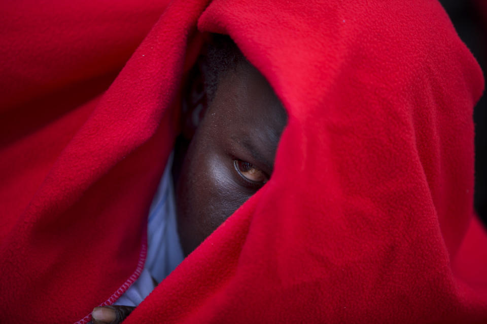 In this Wednesday, June 27, 2018 photo, a migrant rests at the port of Tarifa, southern Spain, as he waits to be transported to a police station after being rescued by Spain's Maritime Rescue Service in the Strait of Gibraltar. The route from northern Africa into Spain has become the most popular for those seeking a better life in Europe, testing Spain’s response networks as the migration debate re-emerges in the region. (AP Photo/Emilio Morenatti)