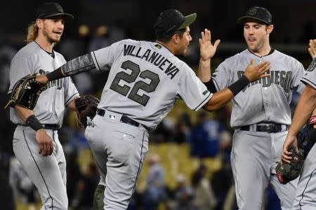 May 26, 2018; Los Angeles, CA, USA; San Diego Padres third baseman Christian Villanueva (22) celebrates the Padres 7-5 win over the Dodgers with teammates at Dodger Stadium. Left to right: outfielder fielder Travis Jankowski, Villanueva (22), San Diego Padres left fielder Matt Szczur, relief pitcher Brad Hand (52) and center fielder Manuel Margot (far right). Villanueva hit two home runs in the game. Mandatory Credit: Robert Hanashiro-USA TODAY Sports