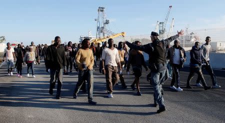 FILE PHOTO: Migrants disembark from Dattilo coast guard vessel in the Sicilian harbour of Augusta, Italy, March 20, 2017. REUTERS/Antonio Parrinello/File Photo