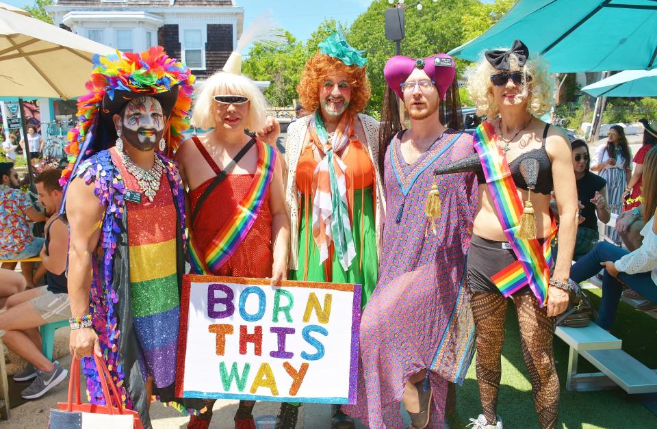 Partiers for a past Provincetown Pride wear rainbow clothing and an important message.