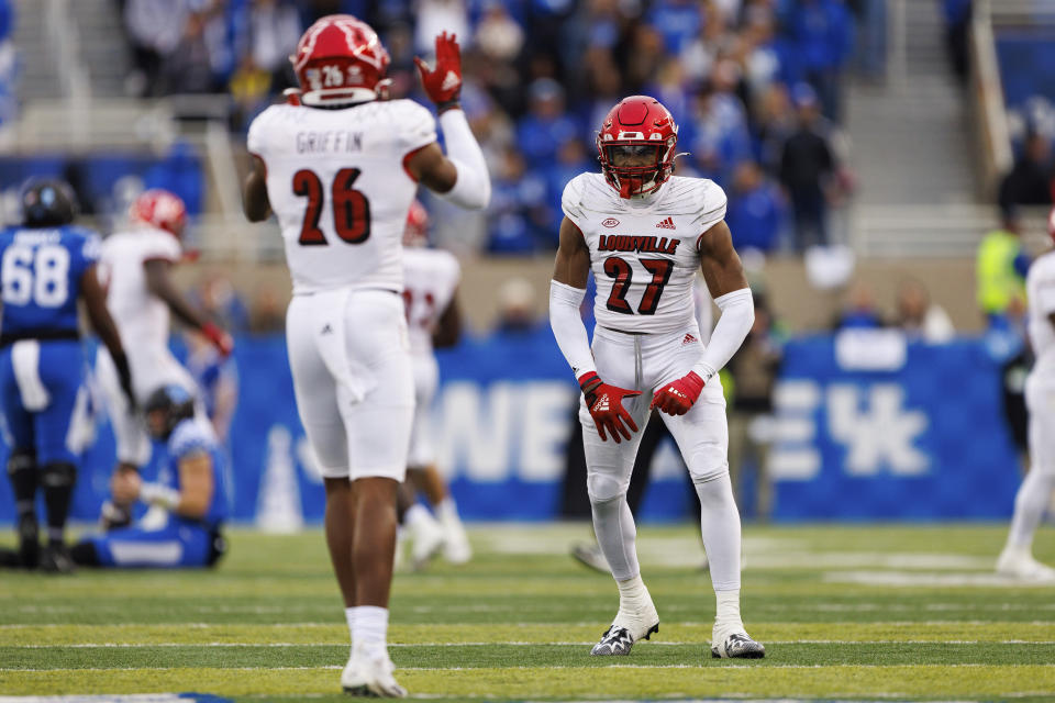 Louisville defensive back Kenderick Duncan (27) and safety M.J. Griffin (26) celebrate getting a stop against Kentucky during the first half of an NCAA college football game in Lexington, Ky., Saturday, Nov. 26, 2022. (AP Photo/Michael Clubb)