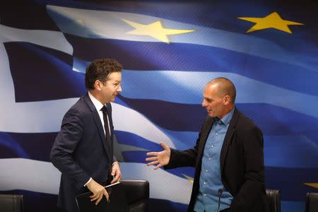 Jeroen Dijsselbloem, (L) head of the euro zone finance ministers' group, and Greek Finance Minister Yanis Varoufakis shake hands after their common press conference at the ministry in Athens January 30, 2015. REUTERS/Kostas Tsironis