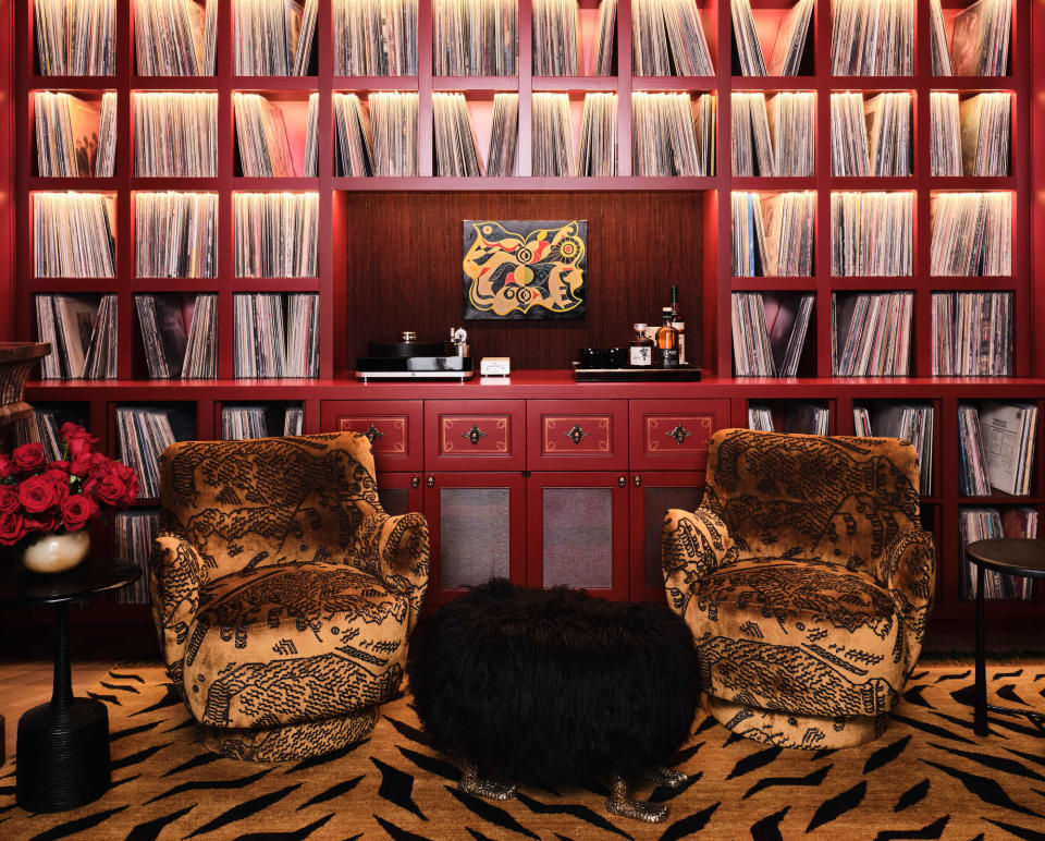 A library with animal patterned rug and arm chairs