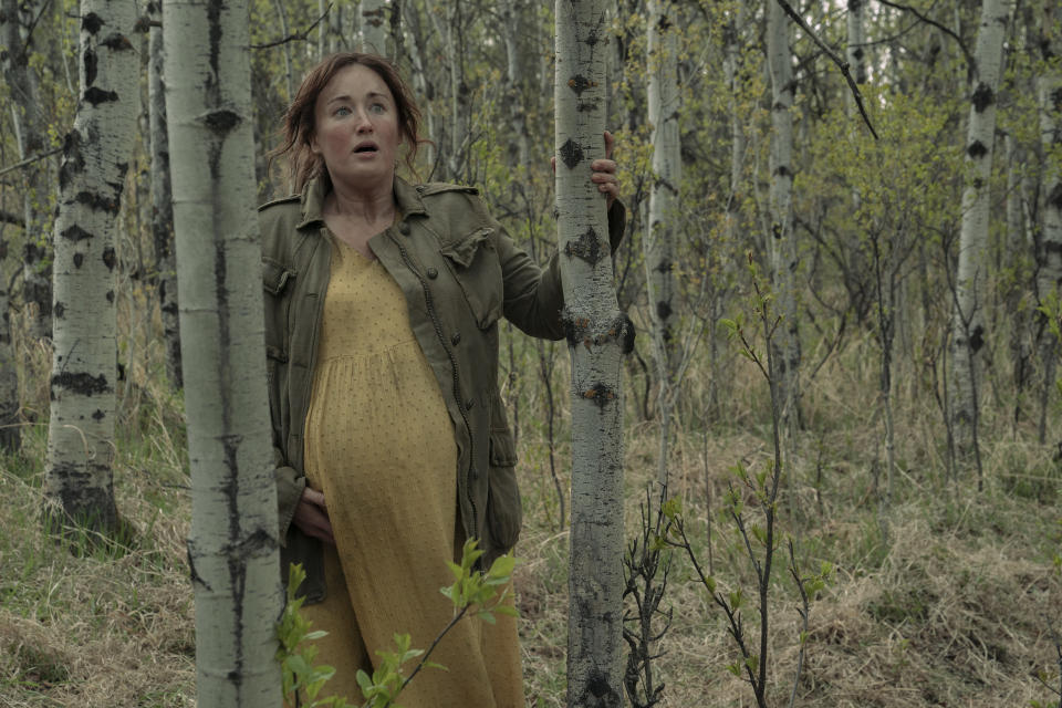Ellie's pregnant mom standing in the woods
