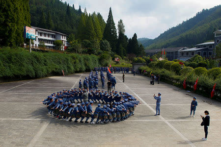 Participants dressed in replica red army uniforms take part in a Communist team-building course extolling the spirit of the Long March, organised by the Revolutionary Tradition College, in the mountains outside Jinggangshan, Jiangxi province, China, September 14, 2017. REUTERS/Thomas Peter