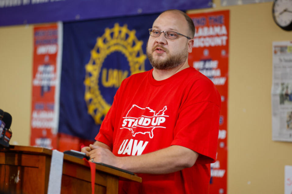 A man in a red shirt at a lectern