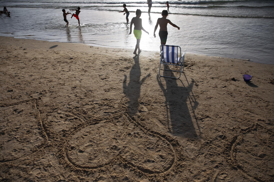 Heart shapes drawn in sand as the sun sets over Tel Aviv's beach, Israel, Saturday, June 12, 2021. (AP Photo/Oded Balilty)