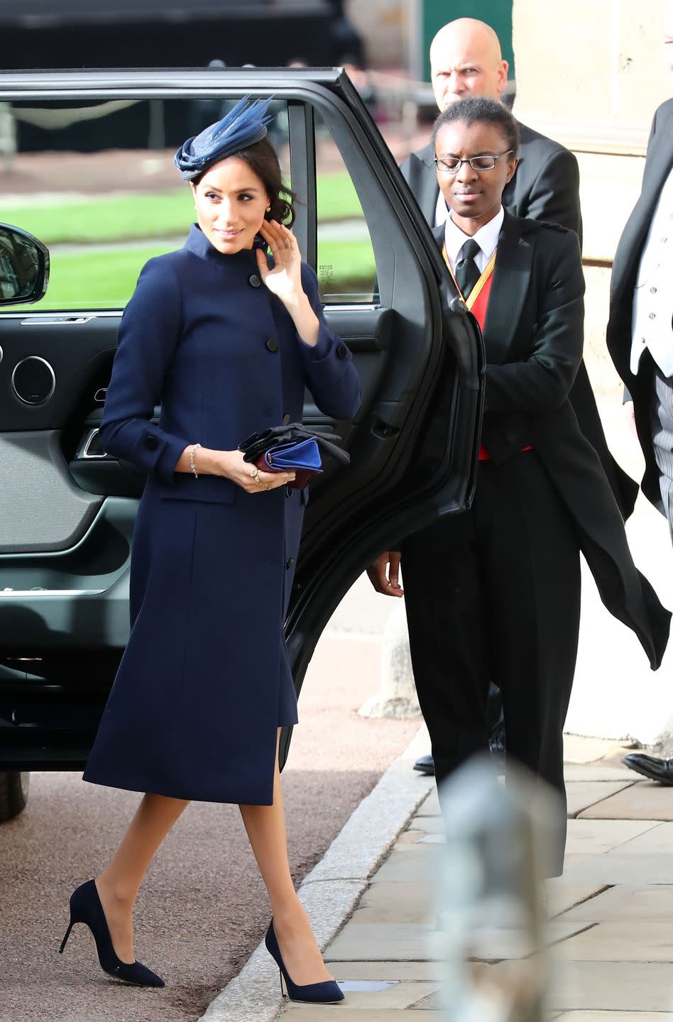 <p>The Duchess wore a navy ensemble by <a href="https://www.net-a-porter.com/gb/en/Shop/Designers/Givenchy?cm_mmc=LinkshareUK-_-TnL5HPStwNw-_-Custom-_-LinkBuilder&siteID=TnL5HPStwNw-qOPzYRvoUQ.lr1p0BIn5Rg&Skimlinks.com=Skimlinks.com&dclid=CObEo73Nx94CFUG8dwodK9QHTQ&pn=1&npp=60&image_view=product&dScroll=0" rel="nofollow noopener" target="_blank" data-ylk="slk:Givenchy;elm:context_link;itc:0;sec:content-canvas" class="link ">Givenchy</a>, alongside her trusty Manolo Blahnik BB pumps and a Noel Stewart fascinator. The secretly pregnant royal held a pair of leather, Prada gloves (<a href="https://www.net-a-porter.com/gb/en/product/1078443/Prada/leather-gloves-" rel="nofollow noopener" target="_blank" data-ylk="slk:similar here;elm:context_link;itc:0;sec:content-canvas" class="link ">similar here</a>).</p>