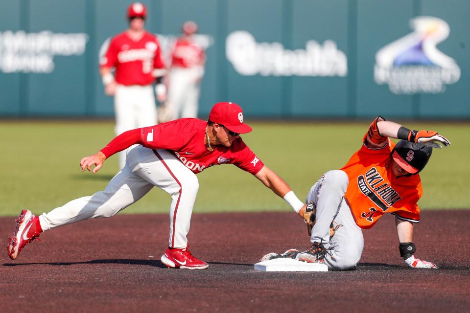 OSU infielder David Mendham (31) slides into second safe as OU infielder Jackson Nicklaus (15) places a tag on him Saturday in Norman.