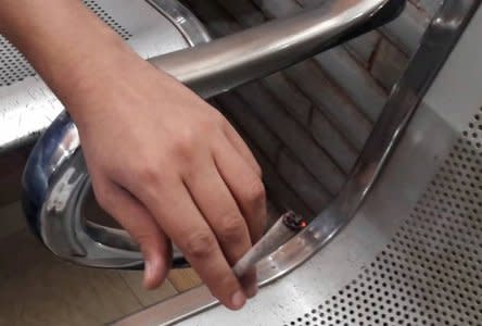 FILE PHOTO: A youth holds a rolled cigarette containing a new kind of drug called