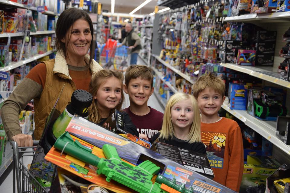 A group of shoppers pose for a photo during the Charlevoix Elementary School shopping spree at Walmart on Monday, Dec. 11, 2023.