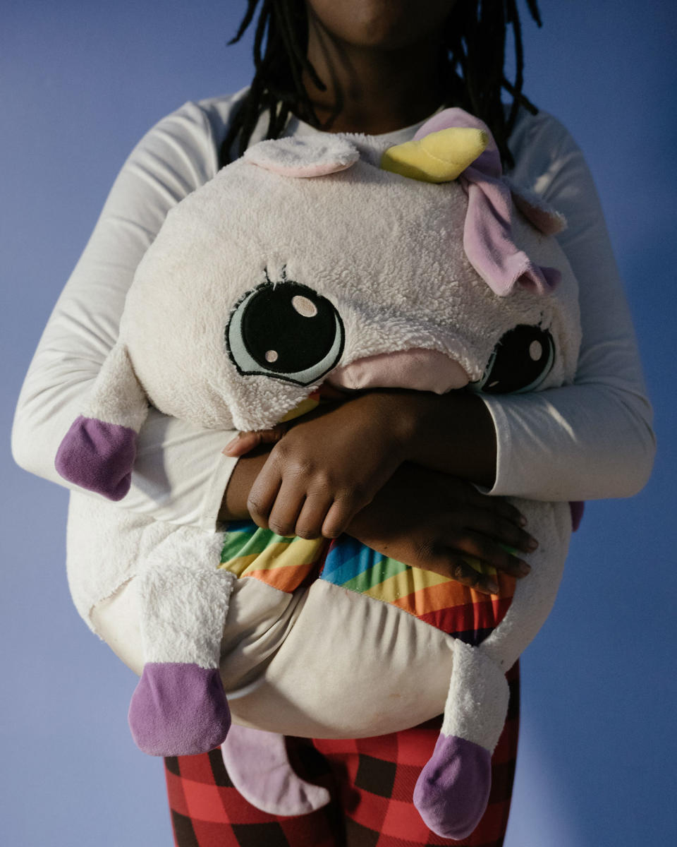 Benton's daughter holds one of her stuffed animals in her bedroom on Dec. 16, 2023. (Caroline Gutman for NBC News)