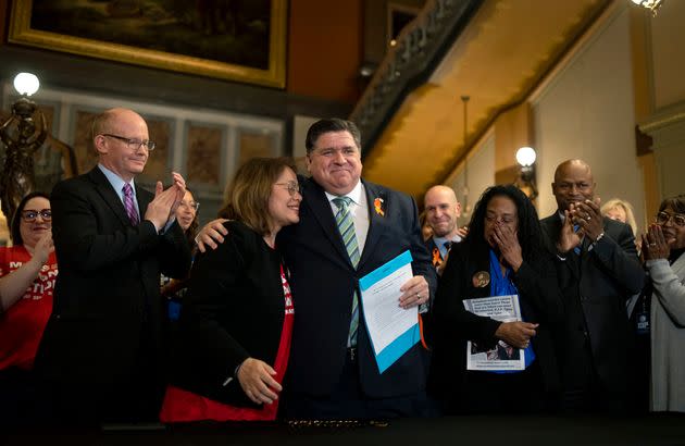 Gov. J.B. Pritzker hugs gun control advocate Maria Pike after he signed comprehensive legislation to ban military-style firearms on Tuesday, at the state capitol in Springfield, Illinois. Pike lost her son to gun violence.