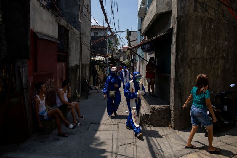 The Wider Image: Hazmat suits and holy water: two priests bring faith to Philippines lockdown