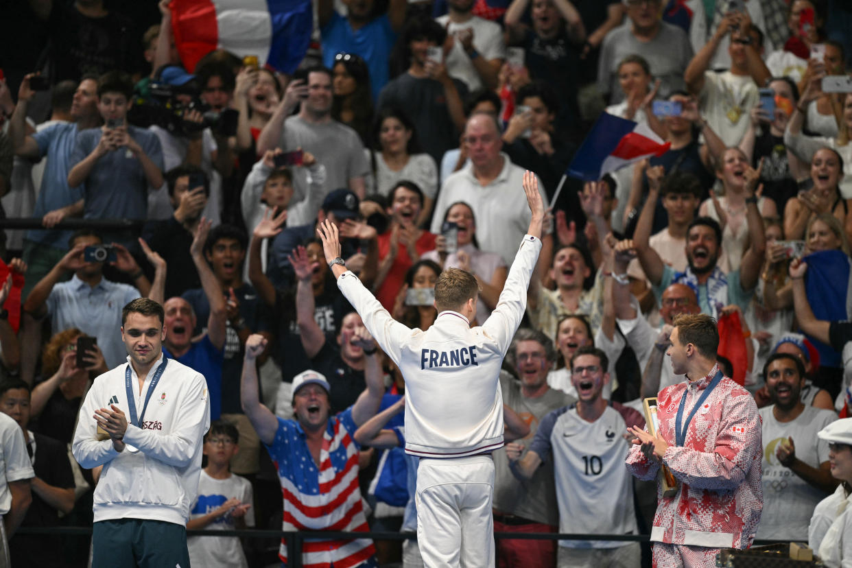 (L-R) Silver medallist Hungary's Kristof Milak, gold medallist France's Leon Marchand and bronze medallist Canada's Ilya Kharun stand on the podium of the men's 200m butterfly swimming event during the Paris 2024 Olympic Games at the Paris La Defense Arena in Nanterre, west of Paris, on July 31, 2024. (Photo by Oli SCARFF / AFP) (Photo by OLI SCARFF/AFP via Getty Images)