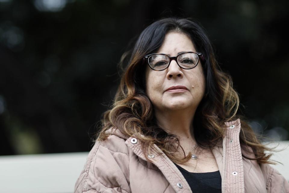 A woman wearing eyeglasses gazes ahead.