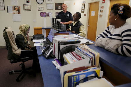 Lewiston Police Officer Patrick Griffin (top C), a community resource officer, talks to workers at the Maine Immigrant and Refugee Services facility in Lewiston, Maine June 1, 2015. REUTERS/Brian Snyder -