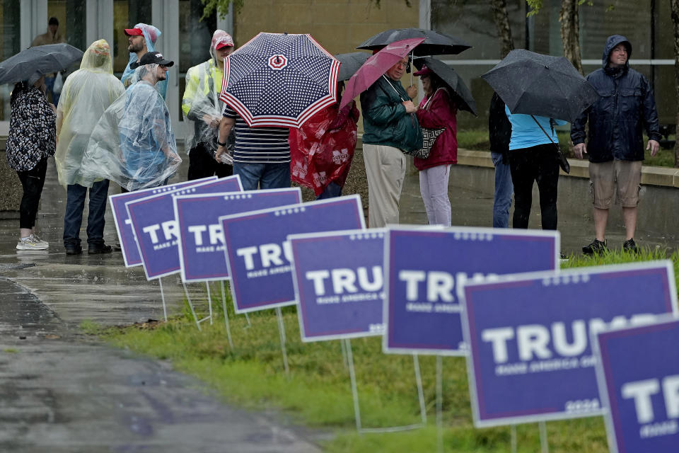 People wait in the rain ahead of a rally for former President Donald Trump, Friday, July 7, 2023, in Council Bluffs, Iowa. (AP Photo/Charlie Riedel)