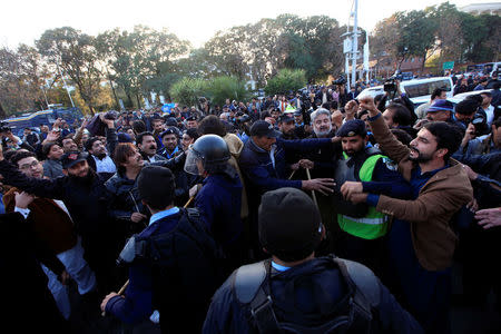 Supporters of Pakistan Tehreek-e-Insaf (PTI) political party, (L) and rulling Pakistan Muslim League Nawaz (PML-N) confront each others after Pakistan's Supreme Court dismissed a petition to disqualify cricket hero and opposition leader Imran Khan from parliament for not declaring assets, in Islamabad, Pakistan December 15, 2017. REUTERS/Faisal Mahmood