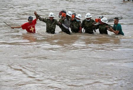 Socorristas recorren un río con motosierras tras un deslave en Mocoa, Colombia, abr 2, 2017. Decenas de cadáveres en descomposición comenzaron a ser entregados el lunes a sus familias para que los entierren, mientras socorristas continúan la búsqueda de víctimas de las inundaciones y deslizamientos de tierra que dejaron al menos 262 personas muertas y devastaron la ciudad colombiana de Mocoa. REUTERS/Jaime Saldarriaga