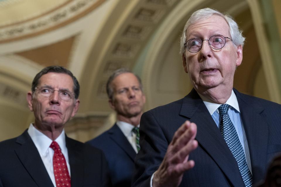 Senate Minority Leader Mitch McConnell of Ky., right, answers a question from a reporter, Tuesday, April 26, 2022, during a news conference on Capitol Hill in Washington. With McConnell are Sen. John Barrasso, R-Wyo., and Sen. John Thune, R-S.D., center. (AP Photo/Jacquelyn Martin)