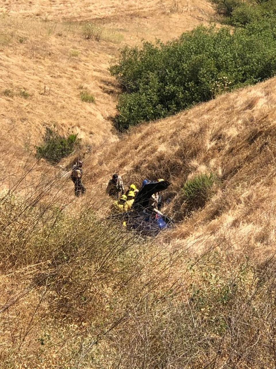 Cal Fire firefighters helped remove two people from the wreck of a Tesla that crashed about 200 feet down a hill on Highway 46 Thursday, July 4, 2024.