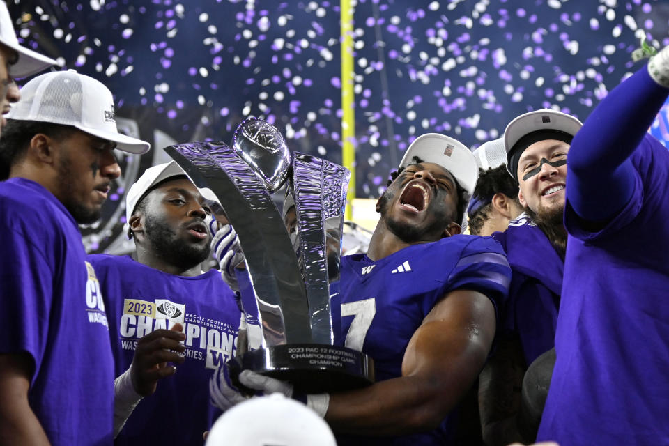 Washington running back Dillon Johnson holds the trophy after Washington defeated Oregon in the Pac-12 championship NCAA college football game Friday, Dec. 1, 2023, in Las Vegas. (AP Photo/David Becker)