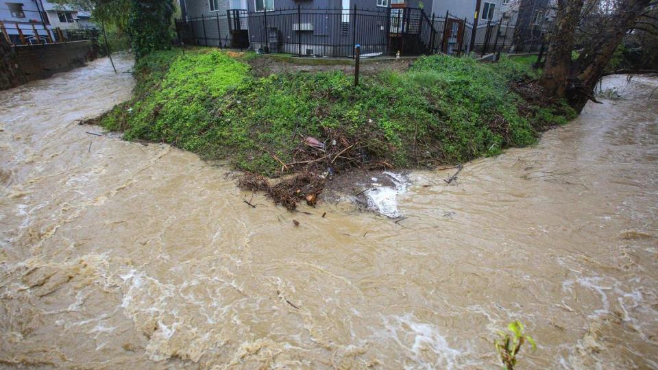 San Luis Obispo Creek takes a hard right angle turn near Dana Street in San Luis Obispo, running brown with mud during an atmospheric river storm on March 14, 2023. David Middlecamp/dmiddlecamp@thetribunenews.com