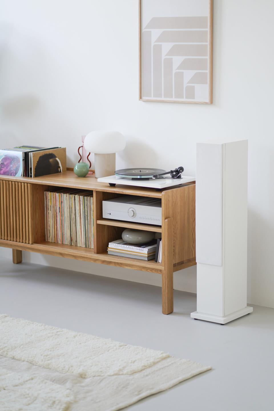 A console table with a record player, records, and a lamp