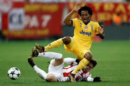 Soccer Football - Champions League - Olympiacos vs Juventus - Karaiskakis Stadium, Piraeus, Greece - December 5, 2017 Juventus’ Juan Cuadrado in action with Olympiacos' Leonardo Koutris REUTERS/Costas Baltas