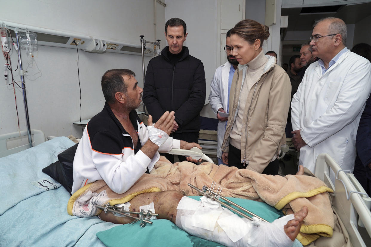 In this photo released by the official Syrian state news agency SANA, Syrian President Bashar Assad, second left, and his wife Asma, visit a wounded survivor of a devastating earthquake, at a hospital in the coastal city of Latakia, Syria, Saturday, Feb. 11, 2023. Syrian state TV said Assad and his wife Asma visited Saturday morning a woman and her son who were pulled out alive the night before from under the rubble of a building in the nearby coastal town of Jableh. (SANA via AP)